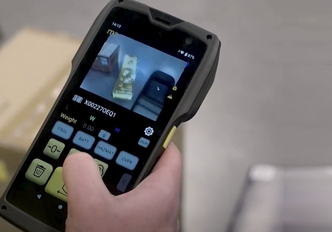 Hand holding the M2 with the dimensioning app on screen