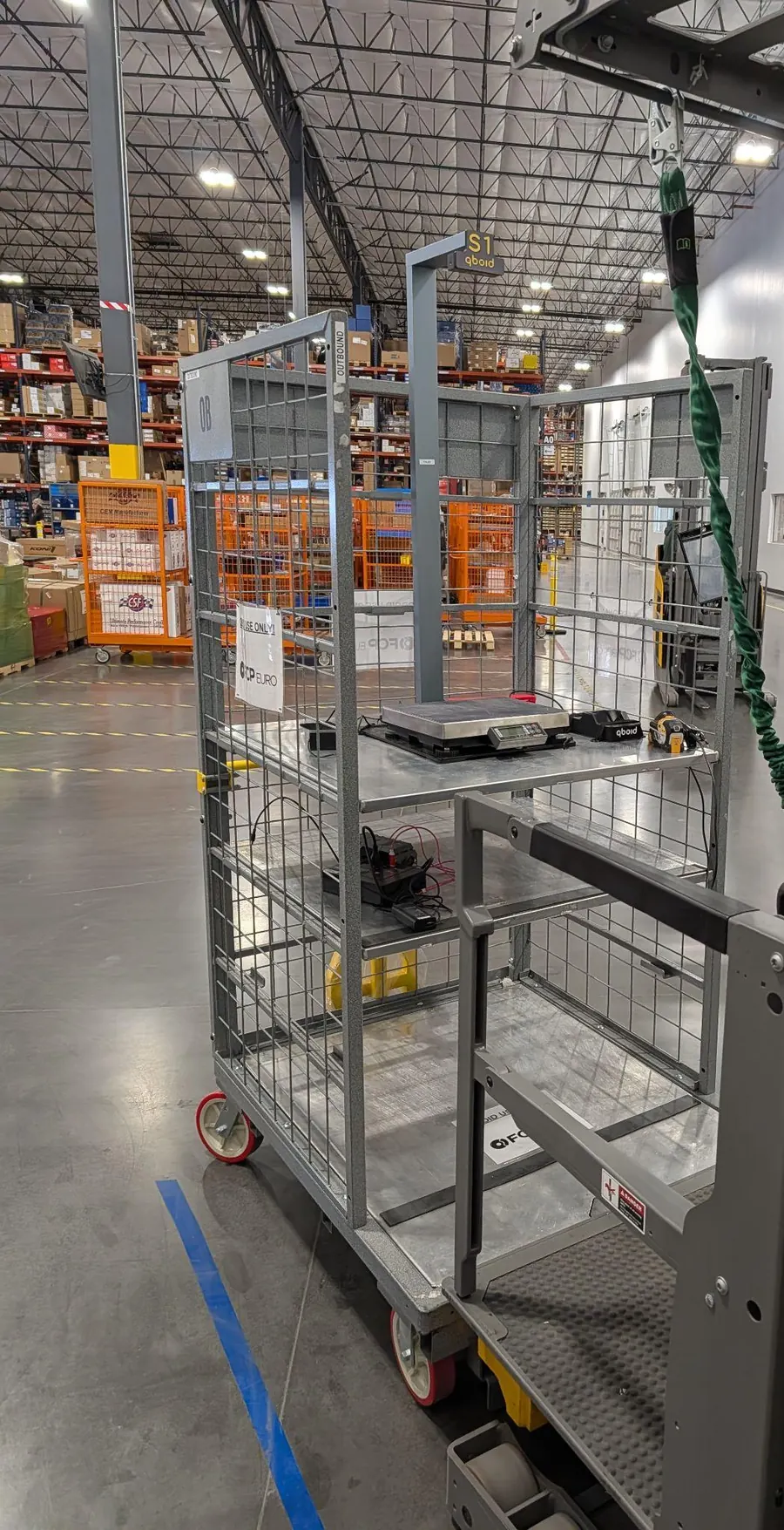 S1 on a cage cart in a warehouse aisle
