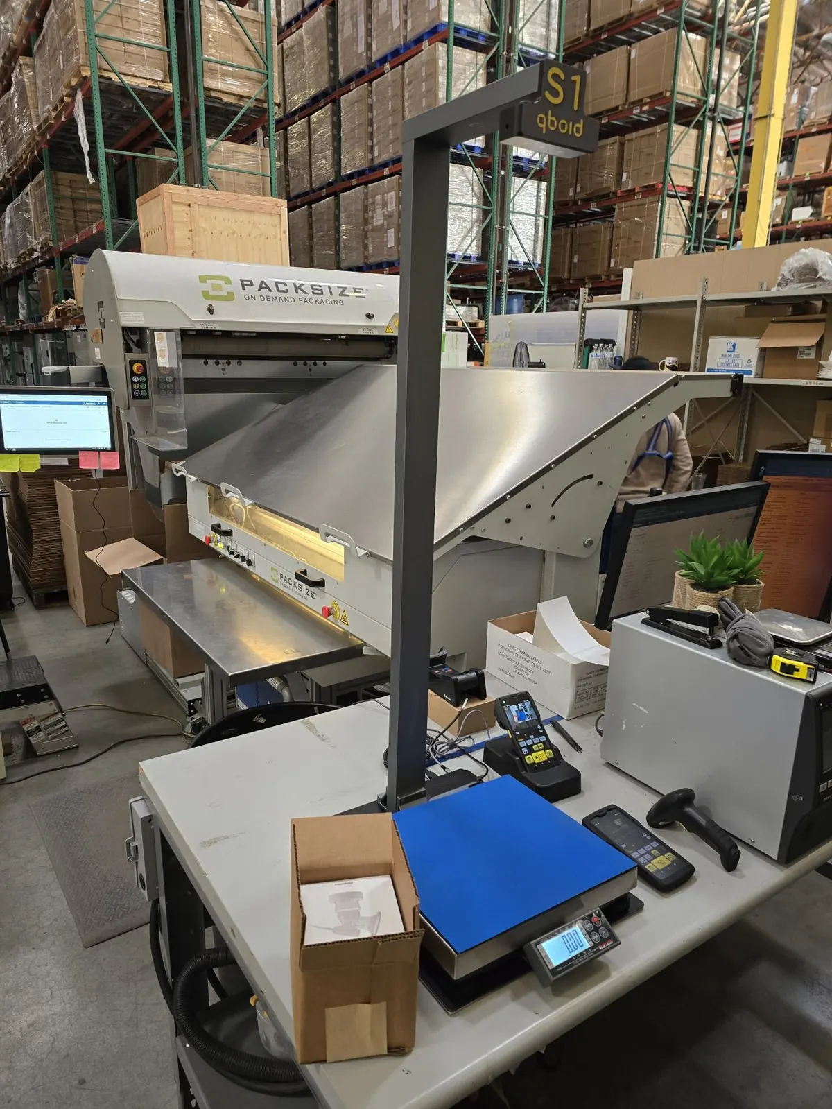 An S1 station with the M2 docked on a receiving bench between warehouse racks