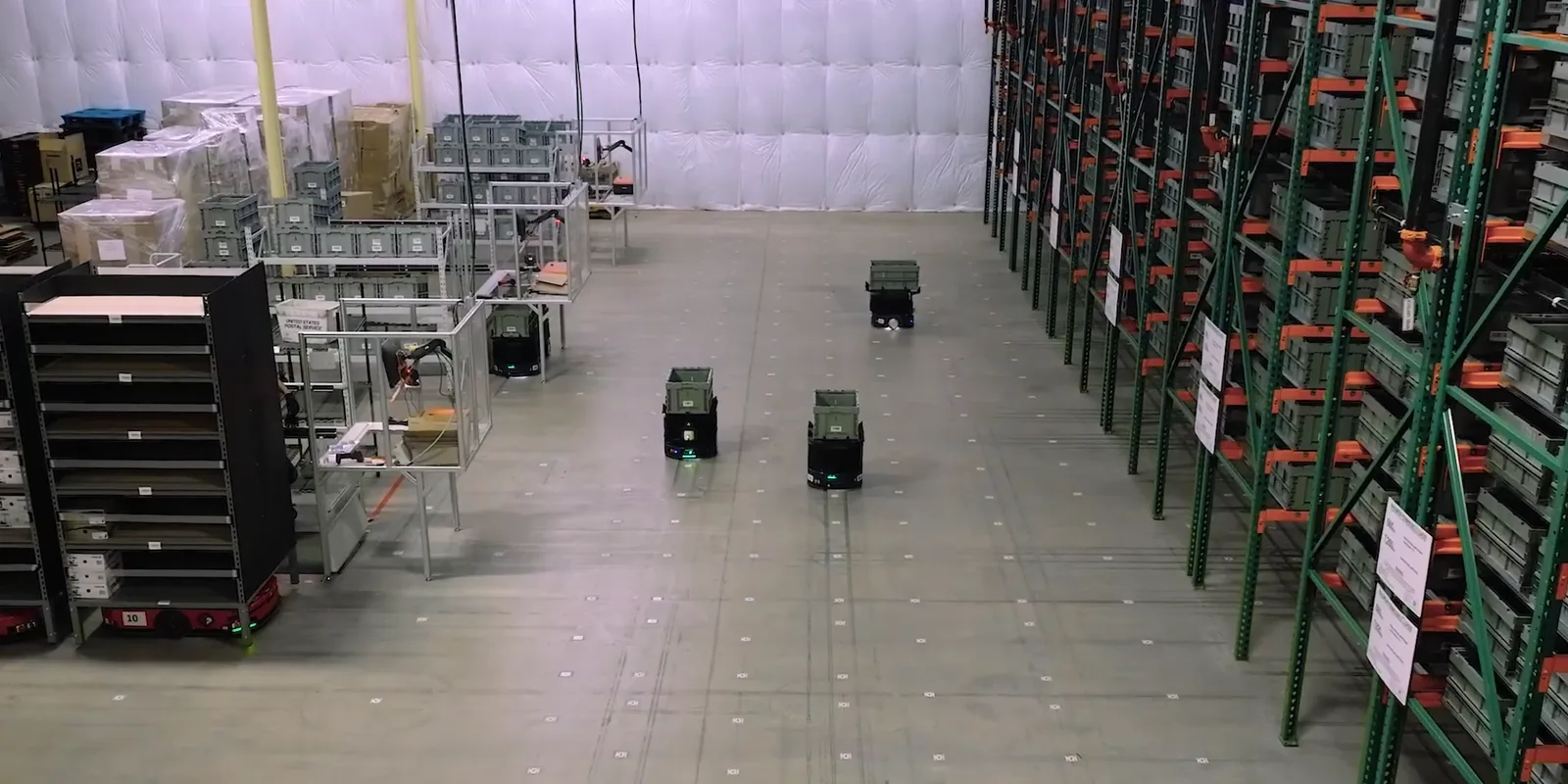 Mobile robots carrying totes across Weby Corp's warehouse floor, next to tall racks of storage bins